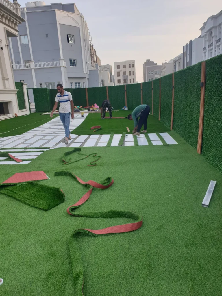 تنسيق حديقة منزلية بالثيل الصناعي في الكويت مع ممرات من البلاط مع شركة تنسيق حدائق بالكويت